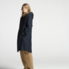 Frau seitlich stehend in Regenjacke