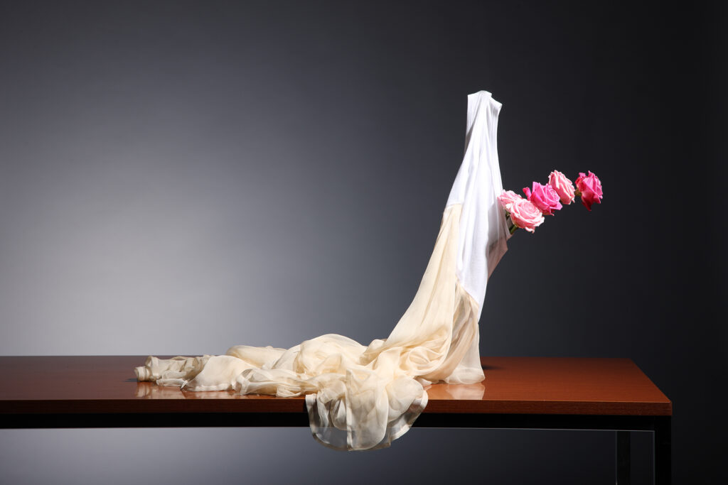 Skulptur aus Textil mit Blumen auf einem Tisch