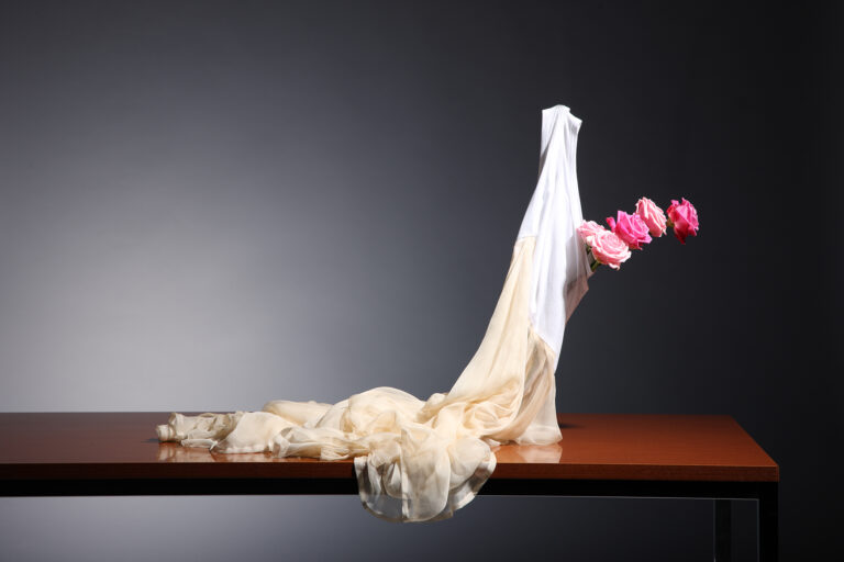 Skulptur aus Textil mit Blumen auf einem Tisch