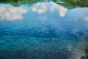 Blauer Bergsee mit Spiegelung im Wasser